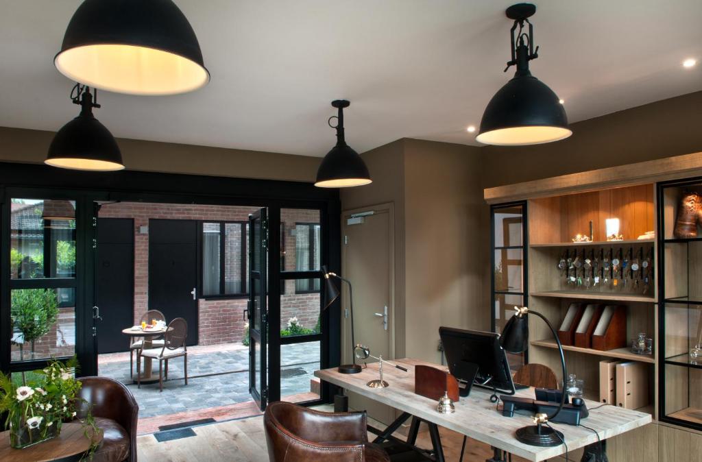 an office with pendant lights and a desk with a laptop at Hotel Les Terres Blanches in Chatou