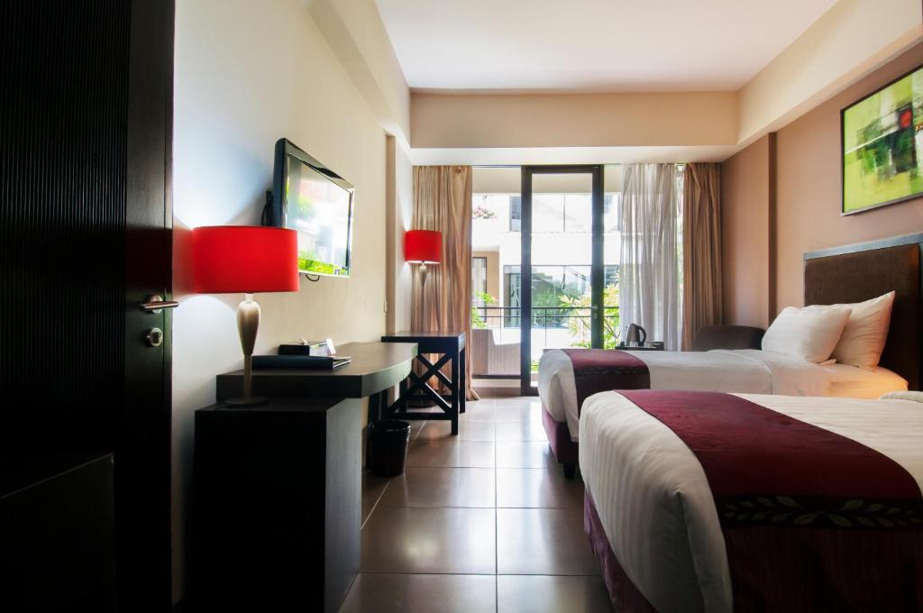 Postel nebo postele na pokoji v ubytování 100 Sunset Kuta Hotel & Ballroom