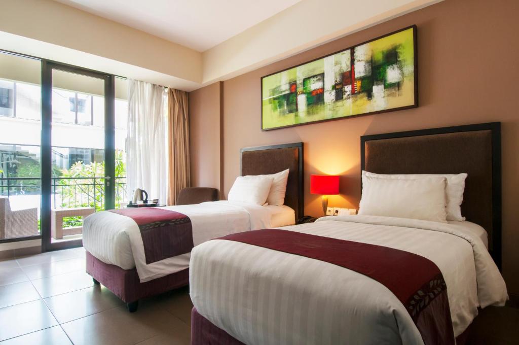 Postel nebo postele na pokoji v ubytování 100 Sunset Kuta Hotel & Ballroom