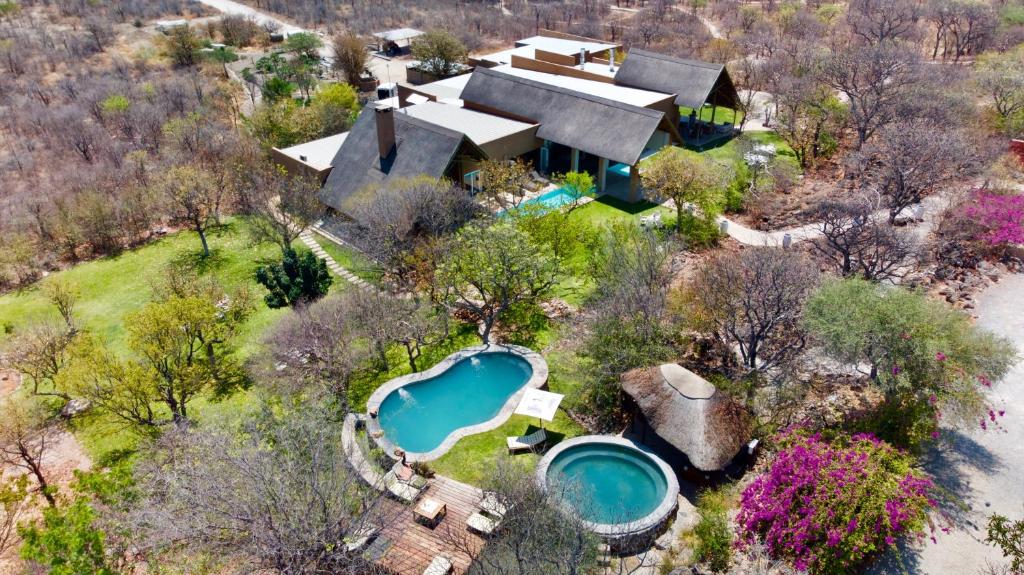 an aerial view of a house with a pool and a resort at Toshari Lodge in Okaukuejo