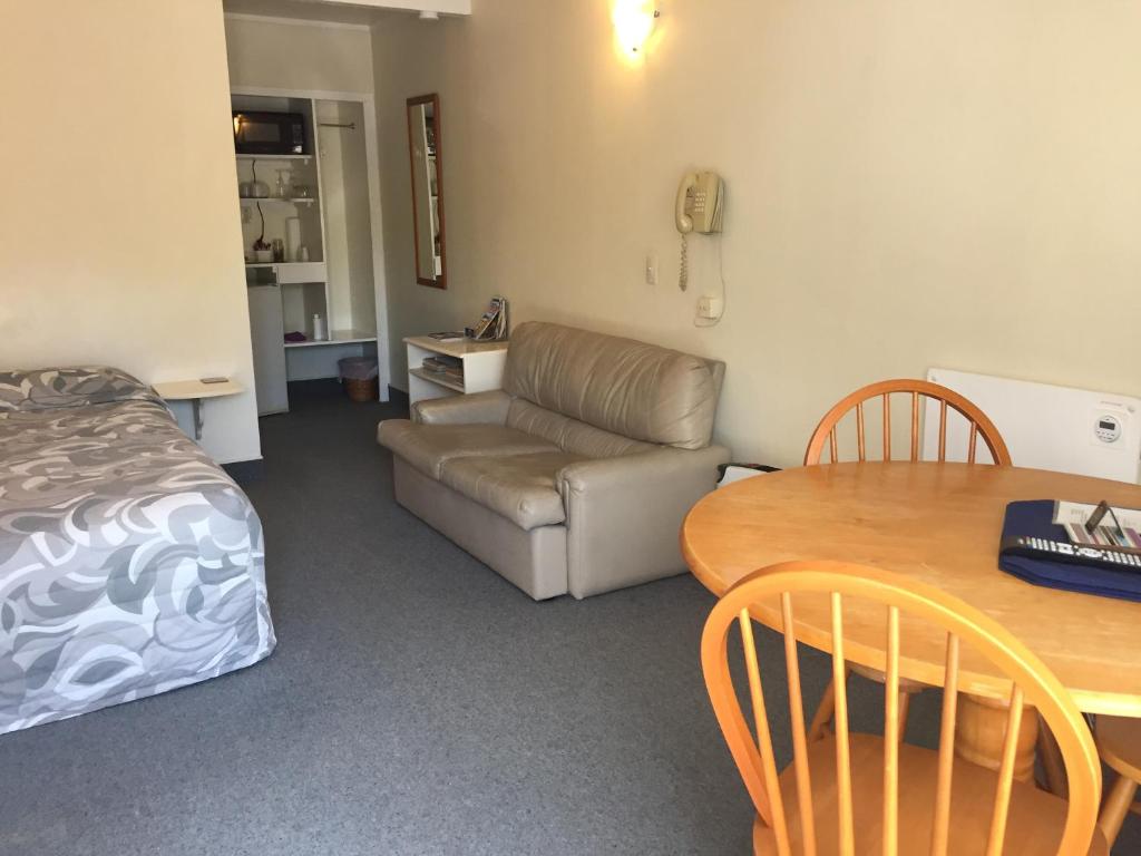 a room with a table and a couch and a table and chair at The Cave Motel in Levin