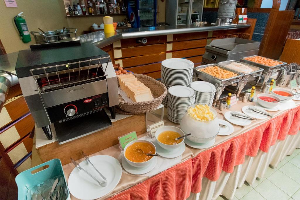 A buffet table serving bread, soup or sauces, fruit and prepared dishes.