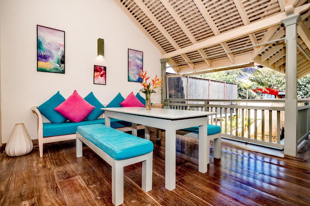 a living room with a table and chairs and a balcony at Small House Boutique Guest House in Galle