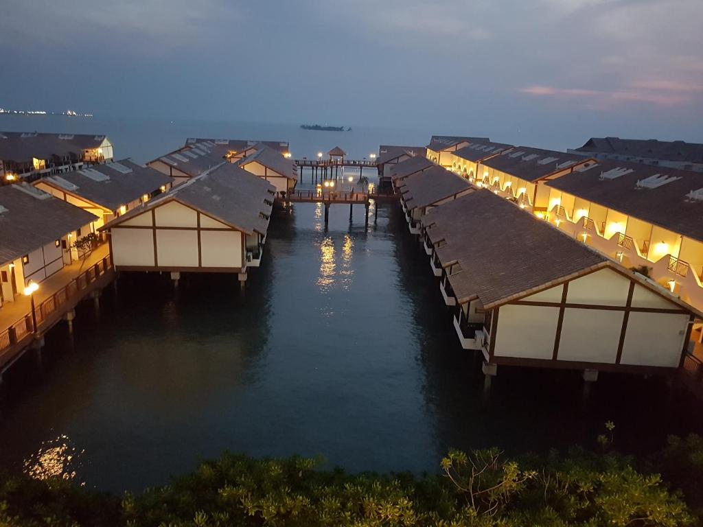 a row of houses on the water at night at Tokido Private Water Chalet PD in Port Dickson