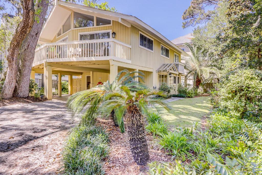 a large yellow house with a palm tree in front of it at Alexander Beach House in Hilton Head Island