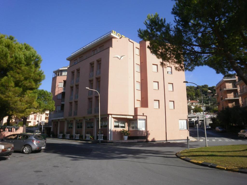 a large building with a parking lot in front of it at Hotel I Due Gabbiani CITR 9006 in Marina di Andora