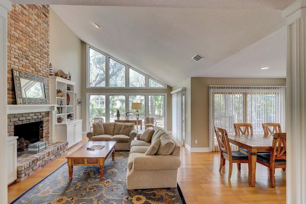 ein Wohnzimmer mit einer Couch, einem Tisch und einem Kamin in der Unterkunft Tupelo Cottage in Hilton Head Island