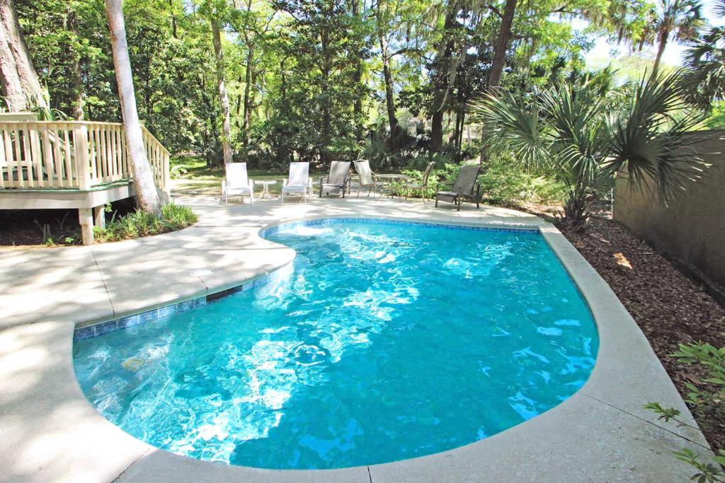 a swimming pool with blue water in a yard at Eagle Watch in Hilton Head Island