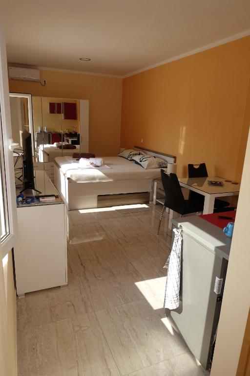 een kamer met 2 bedden, een tafel en een bureau bij Apartments Leon Nin in Nin