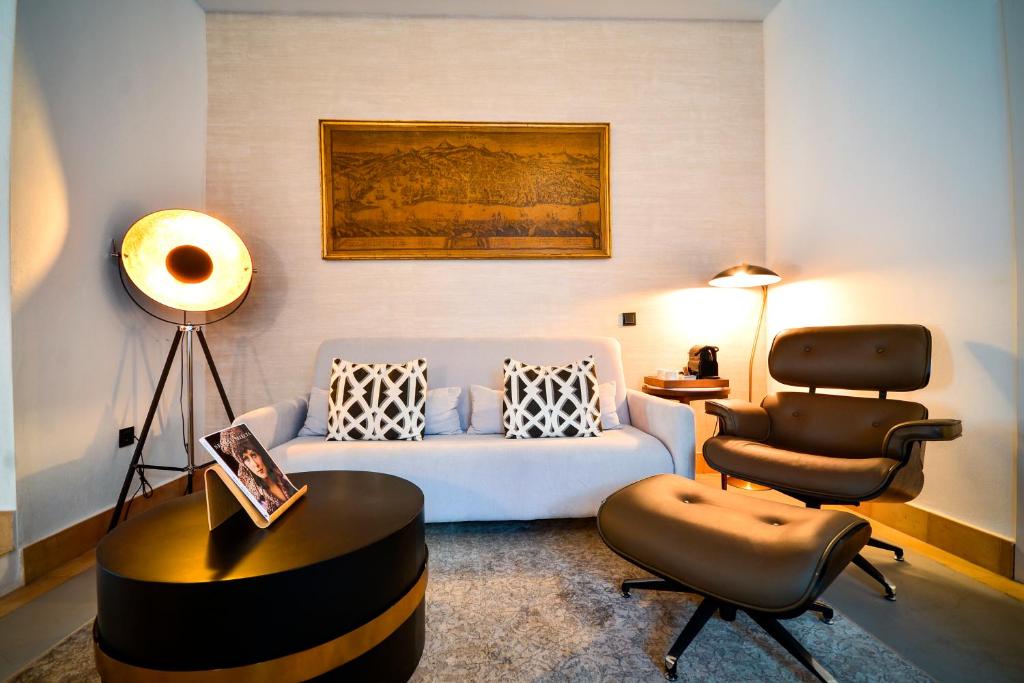 a living room with a couch and a chair at Hotel Legado Alcazar in Seville