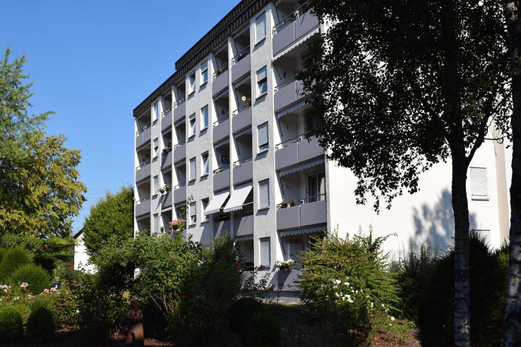 un grand bâtiment blanc avec des arbres devant lui dans l'établissement Gästehaus Schumm, à Murrhardt