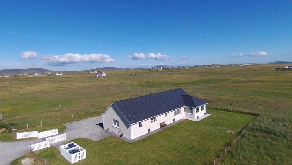 an aerial view of a white house in a field at Tranquil Sands Holiday Home in Paible