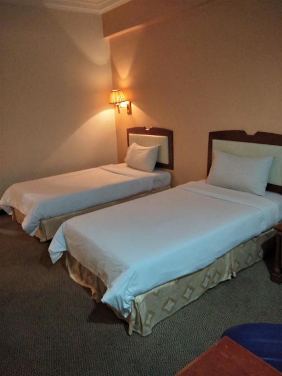 Postel nebo postele na pokoji v ubytování King Park Hotel Tawau