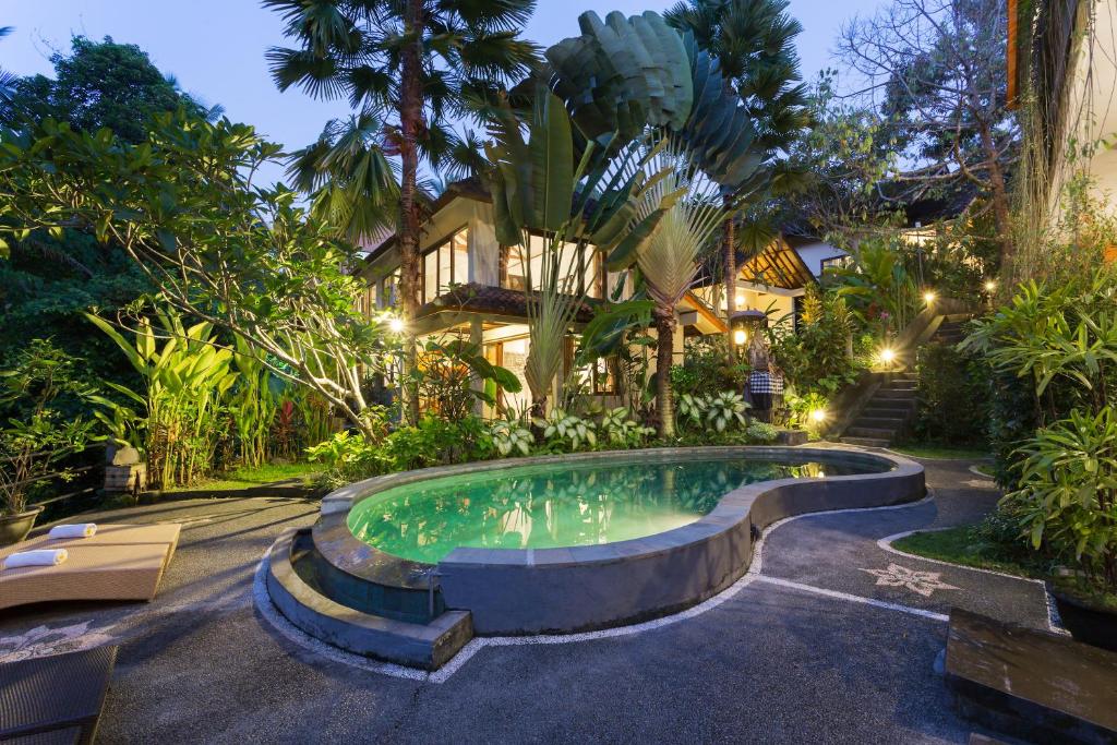 uma piscina em frente a uma casa com árvores em Rahayu Suites Monkey Forest Ubud em Ubud