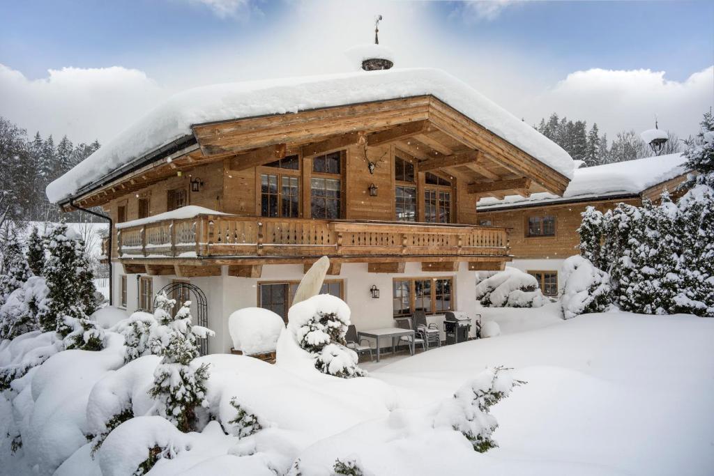 una grande casa in legno coperta di neve di Haus Bella a Ellmau