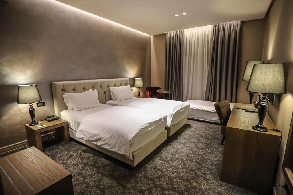 En eller flere senger på et rom på Mondial Hotel