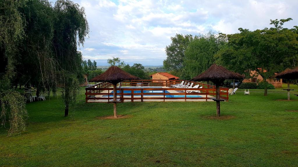 un parque con un pabellón con sillas y sombrillas en Cabañas Landhaus en Villa General Belgrano