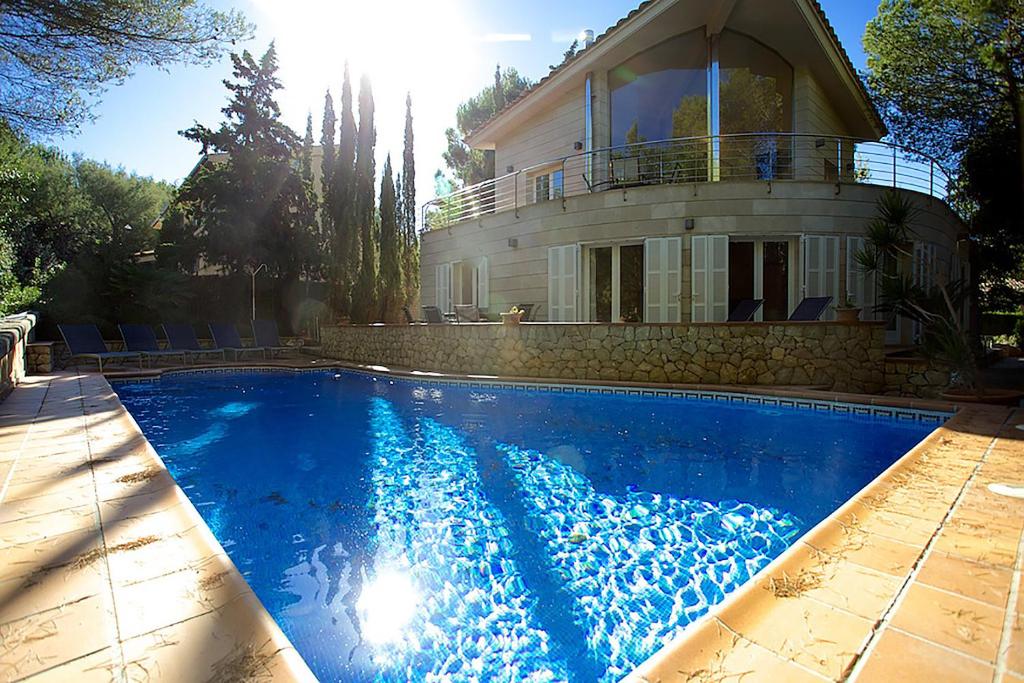 una casa con piscina frente a una casa en Villa Narcis, en Alcudia