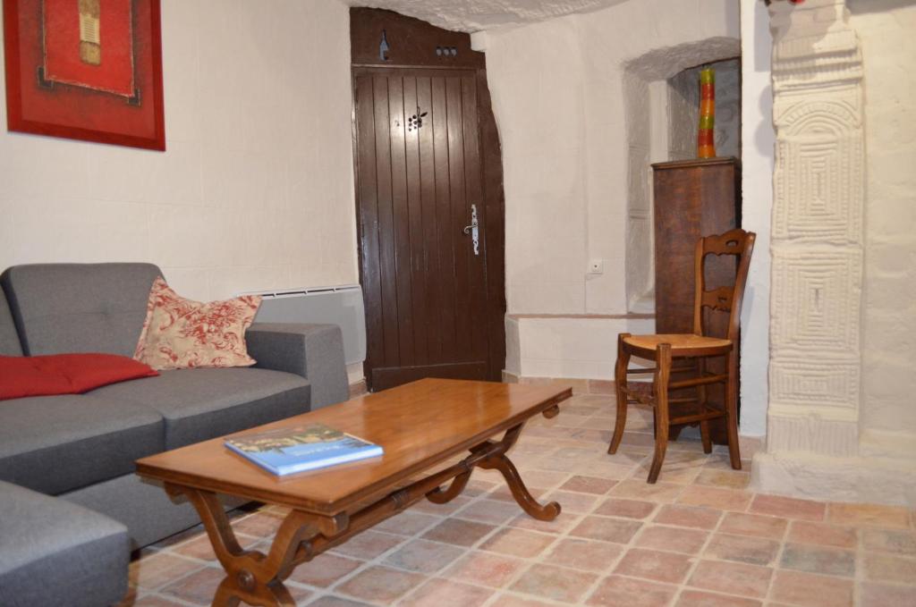 a living room with a couch and a coffee table at Les Troglos de l'Echeneau in Vouvray