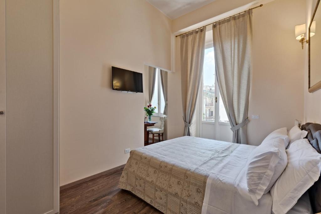 a white bedroom with a bed and a window at Vatican Domus Luxury Rooms in Rome