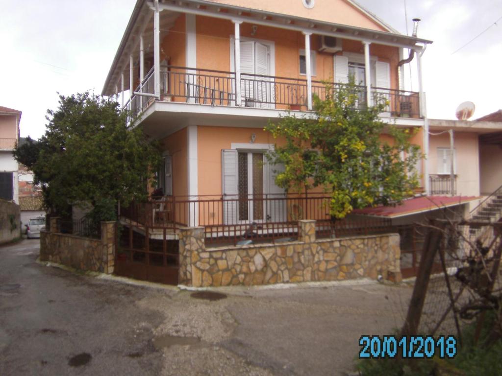 a house with a stone wall and a balcony at George's House in Ágios Matthaíos