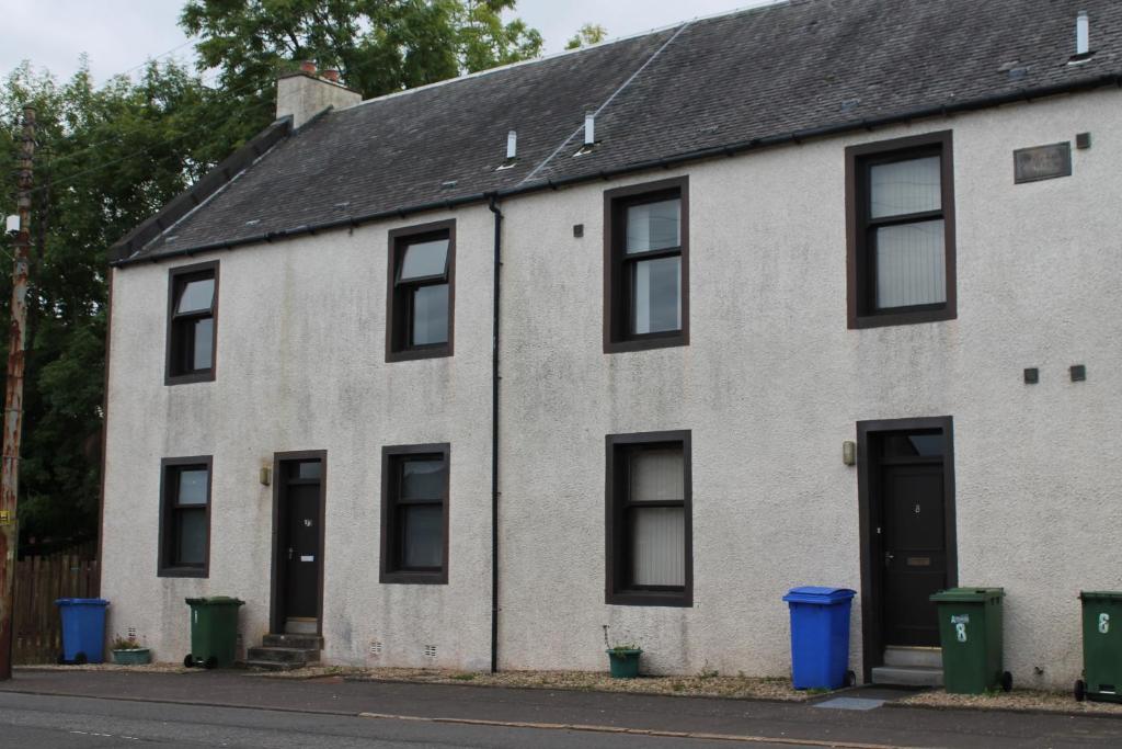 an old white house with black windows and doors at Welltrees Apartments 8 Dailly Road in Maybole