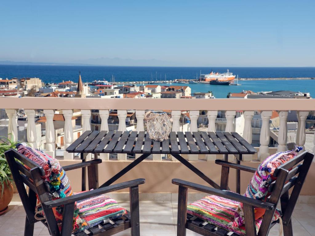 a table and chairs on a balcony with a view at THREE GRACES ZAKYNTHOS TOWN in Zakynthos Town