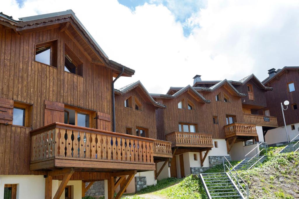 Une rangée d'immeubles d'appartements avec balcon en bois dans l'établissement Madame Vacances Les Chalets du Praz, à La Plagne
