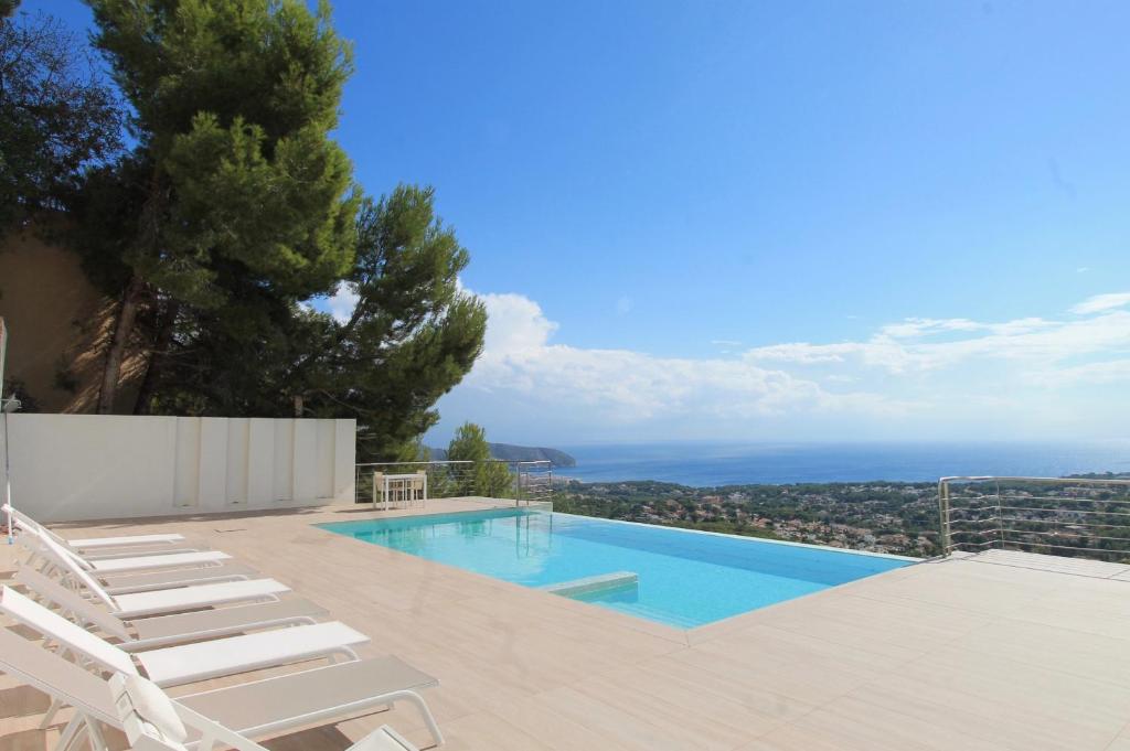 una piscina con 2 tumbonas y una piscina en Villa Wivine, en Moraira