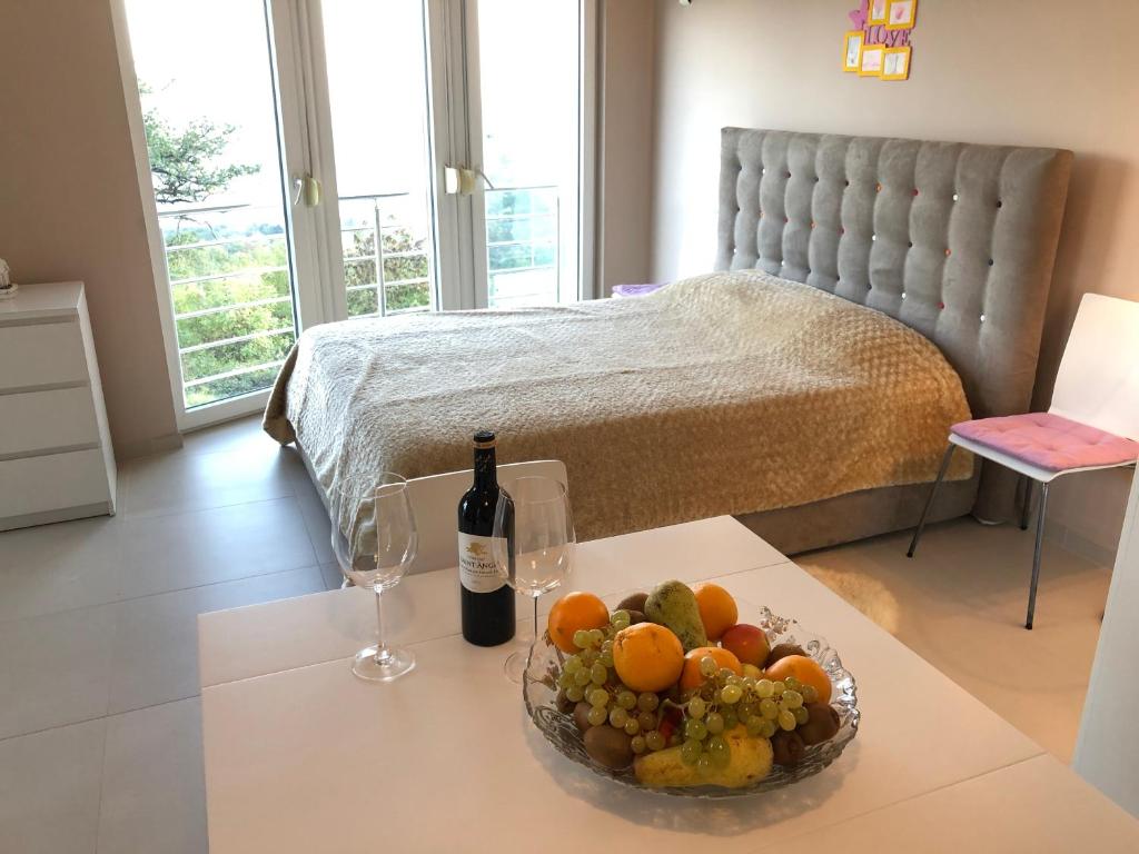 - une table avec un bol de fruits et une bouteille de vin dans l'établissement Studio Apartments Santa, à Marčići