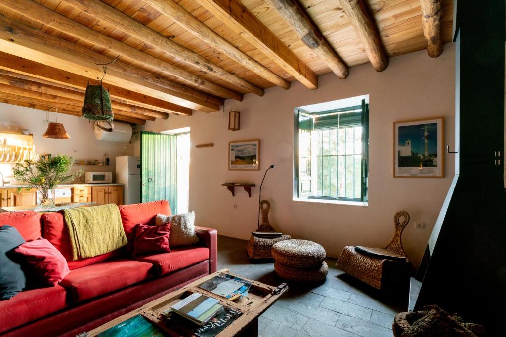 sala de estar con sofá rojo y mesa en Casa de los Curas, chimenea 2 Hab 4 Pers Max, en Puerto de la Laja