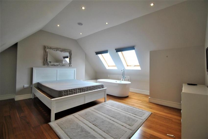 a bedroom with a bed and a tub and a sink at Flat 4, 15 Ethelbert Square CT8 8SR in Westgate-on-Sea