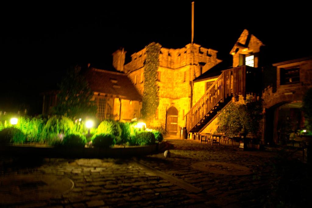 an old building with lights in front of it at night at Alnwick Lodge West Cawledge Park in Shilbottle