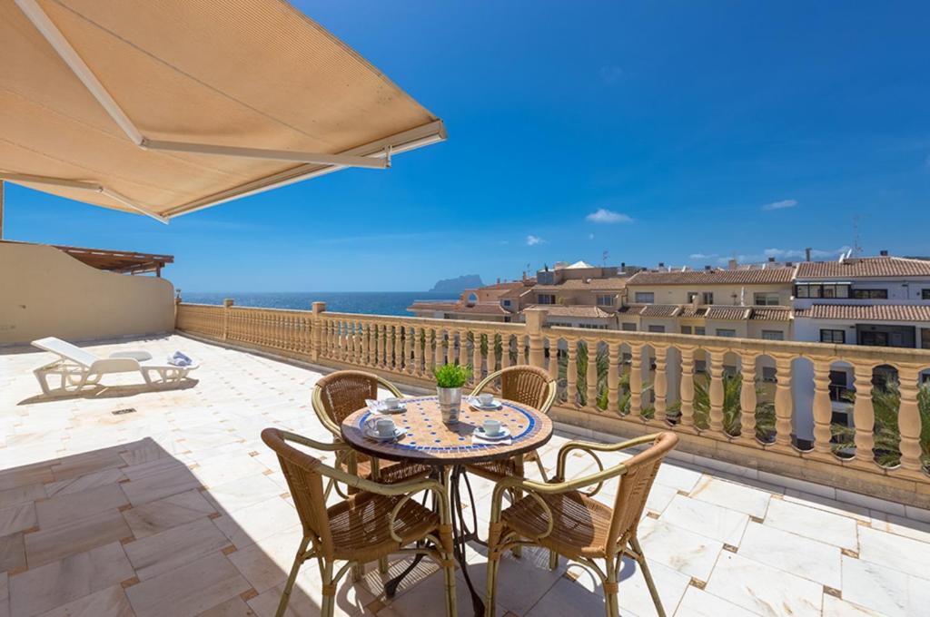a patio with a table and chairs on a balcony at Villas Guzman - Apartamento Cap Dor in Moraira