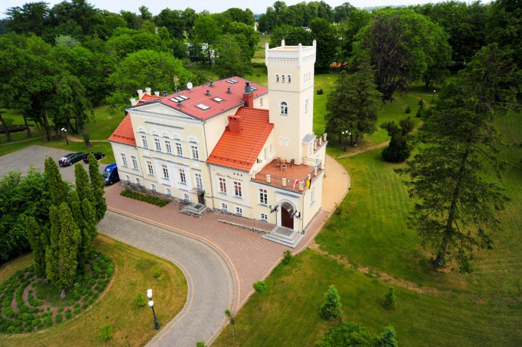 una vista aérea de una gran casa blanca con techo rojo en Hotel SPA Wieniawa en Rekowo