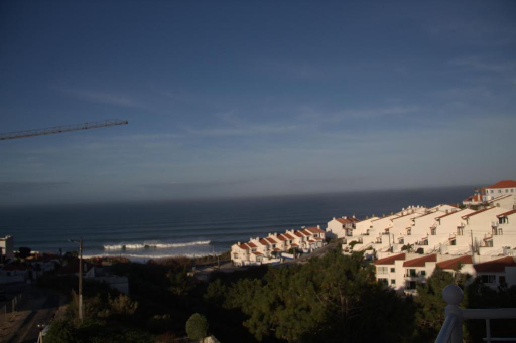 a view of a town with houses and the ocean at Ericeira Sunset Apartment in Ericeira