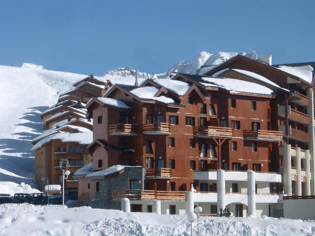 un gran edificio en la nieve con nieve en Madame Vacances Lodges des Alpages en La Plagne