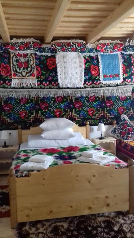 a bedroom with a bed with blankets and pillows at Sub Creasta Cocosului in Breb