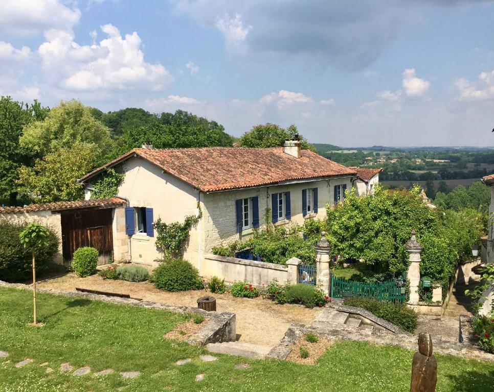 een wit huis met een hek en een tuin bij Grange Bleuet in Aubeterre-sur-Dronne