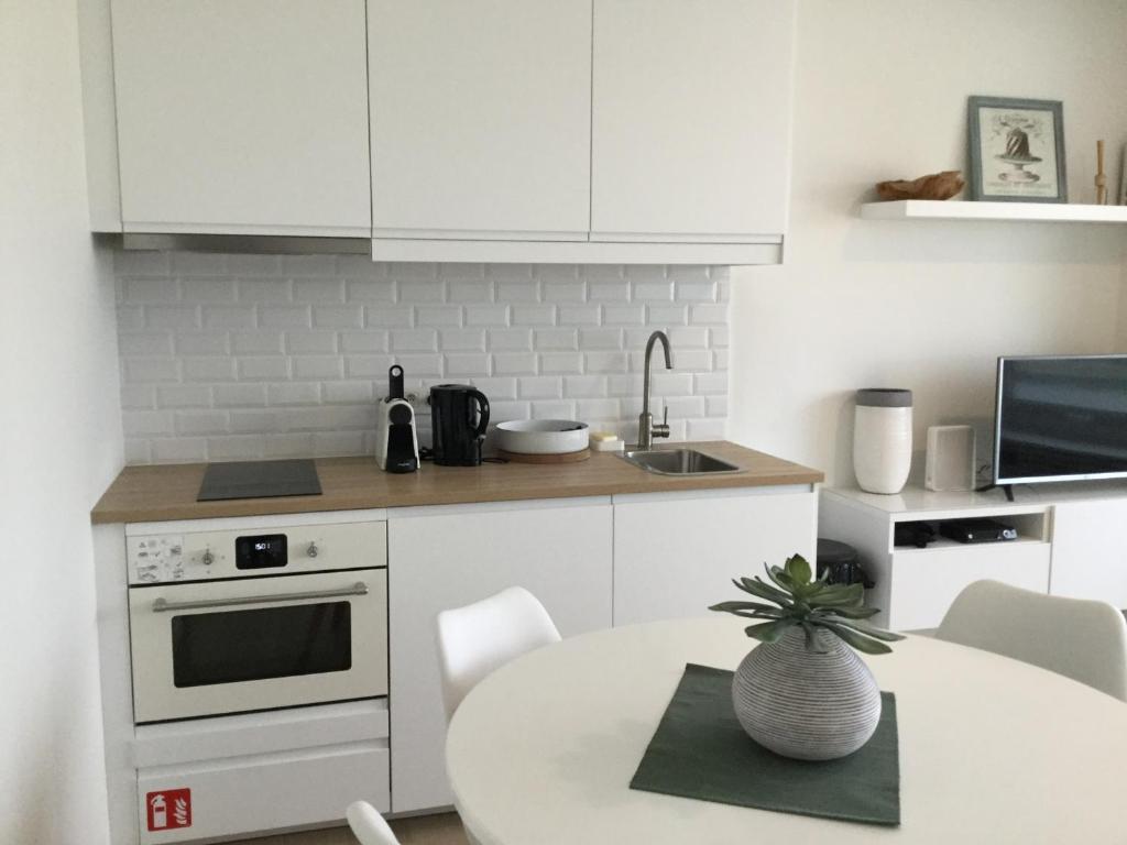 a kitchen with white cabinets and a table with a plant at hill4 in Ostend