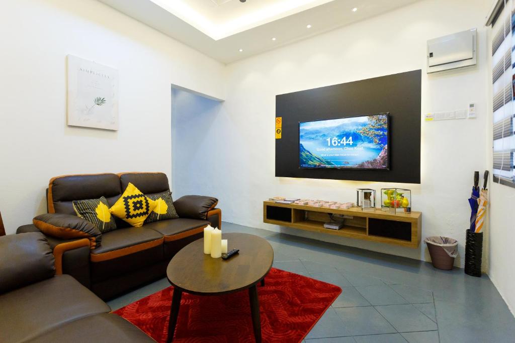 een woonkamer met een bank en een flatscreen-tv bij Jia Residence in Melaka