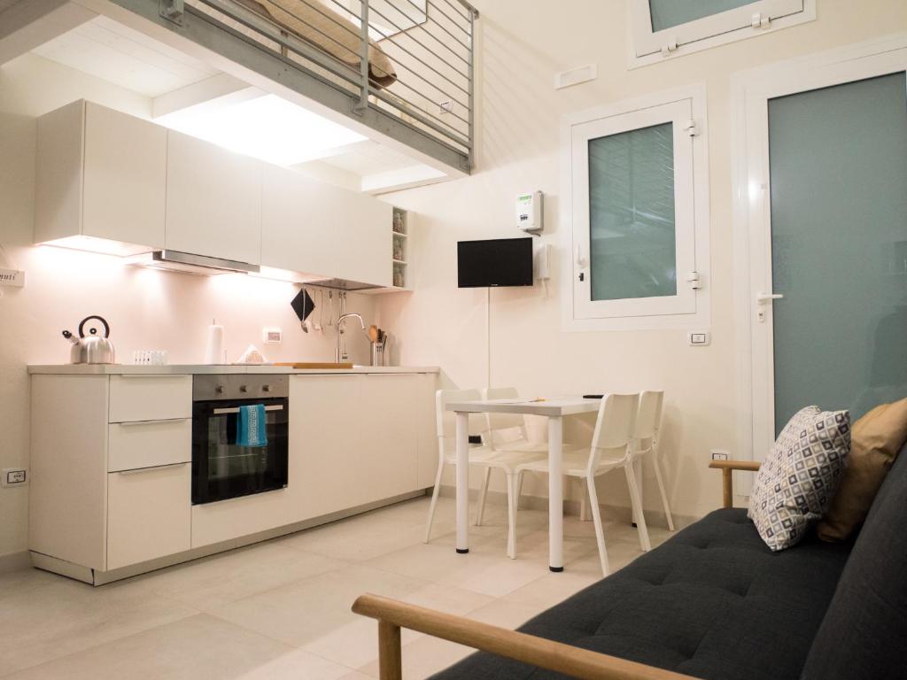 バーリにあるSan Nicola Studio Apartments - Barivecchiaのキッチン、リビングルーム(テーブル、ソファ付)