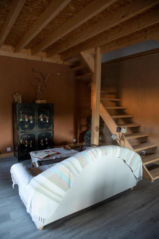 a large bed in a room with a staircase at Le Chat Blanc in Versols-et-Lapeyre