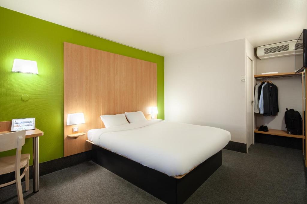 エルブレにあるB&B HOTEL Herblayの緑の壁のベッドルーム1室(白いベッド1台付)