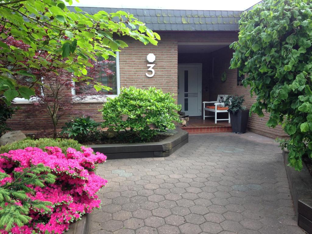 a house with pink flowers in front of it at Ferienwohnung Lortz in Cuxhaven