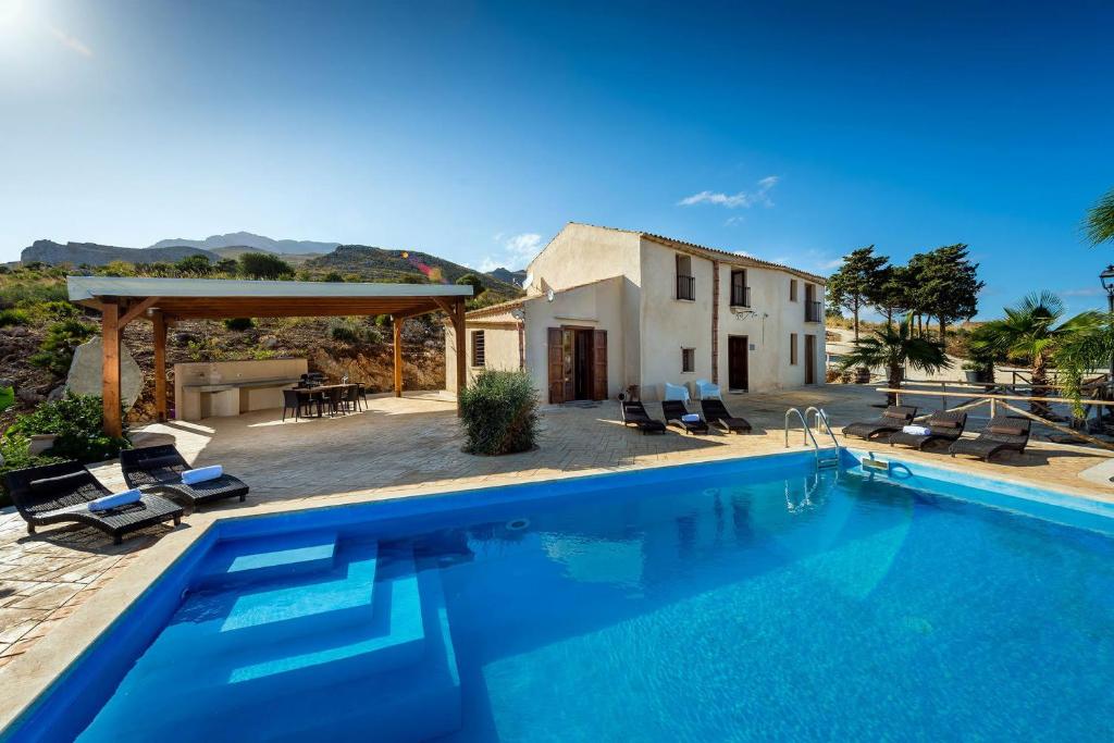 a villa with a swimming pool in front of a house at Villa Thalia in Castellammare del Golfo