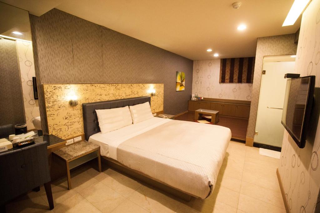 a bedroom with a large bed and a television at Love Hotel in Pingtung City
