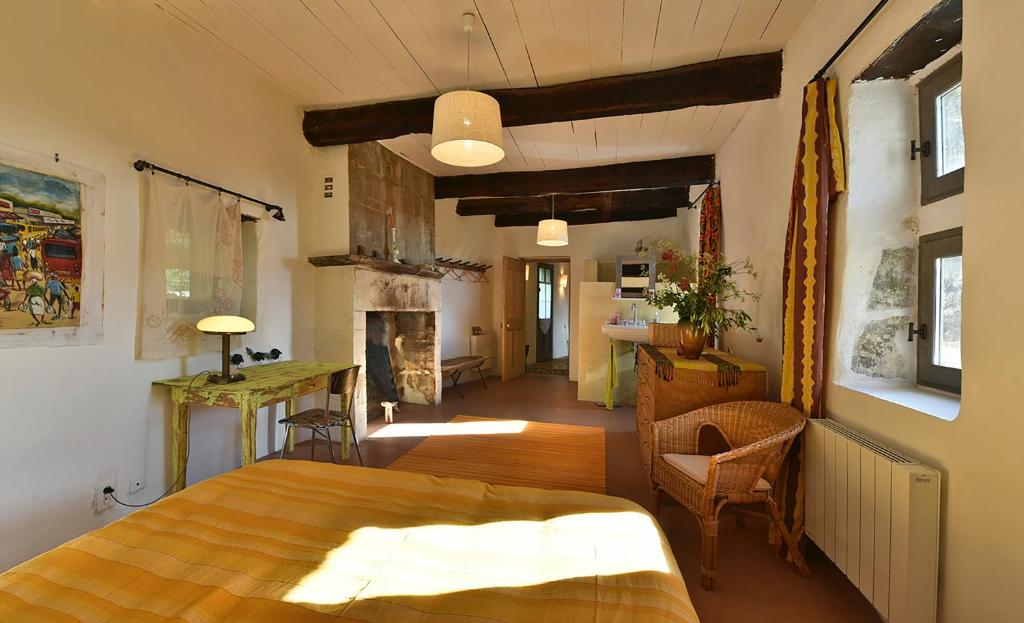 sala de estar con mesa de madera y chimenea en B&B Champdelaplume, en Barjac
