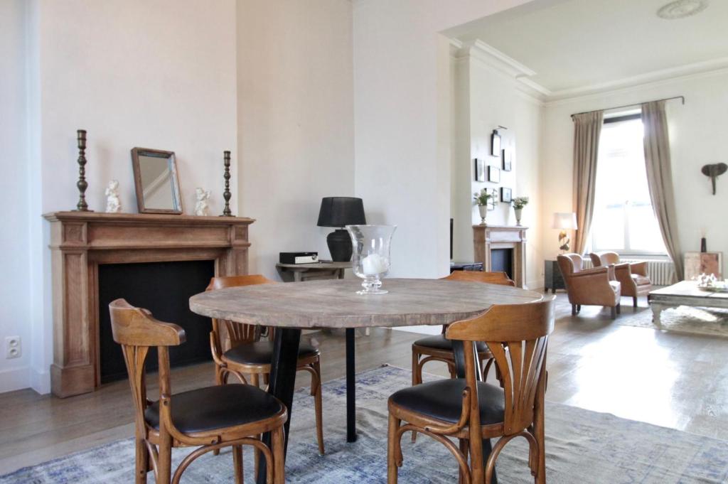 ein Wohnzimmer mit einem Holztisch und Stühlen in der Unterkunft Cap's House in Gent