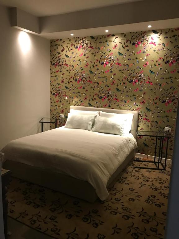 una camera da letto con un letto e carta da parati floreale di Olimpia House room a Verona